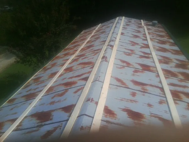 Rusted metal roof panels with new wood purlins before replacement — Storm Damage Roof Repair in Stokes by Roofing Brothers
