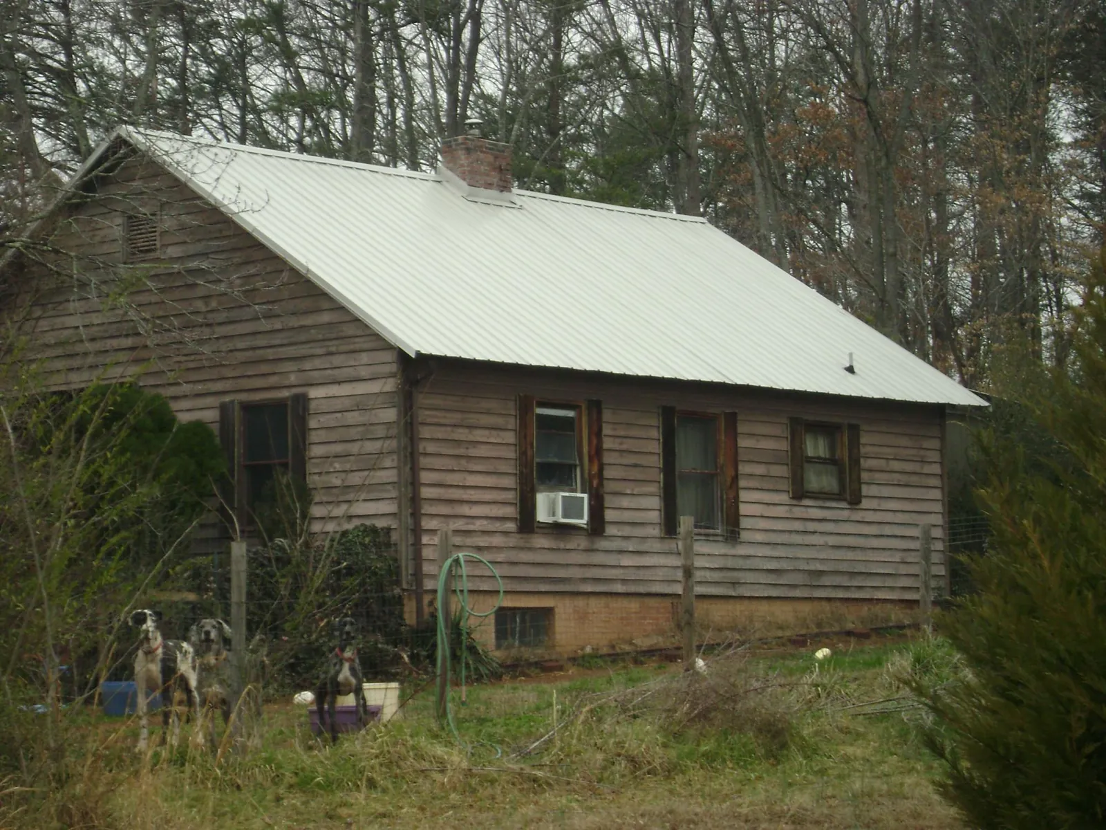 White metal roof on an old wood sided farmhouse, from a Metal Roof Installation job in Stokes